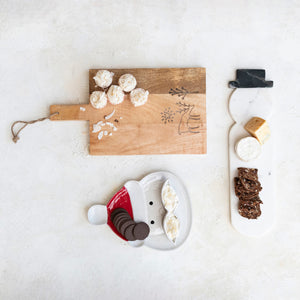 The CREATIVE COOP MARBLE SNOWMAN CHEESE CUTTING BOARD features subtle gray and brown veining, a round handle, and a small black accent—an elegant choice for entertaining, shown on a white background.
