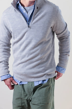 RELWEN - Wool and Cotton Quarter Zip in Light Grey Heather, a long-sleeve pullover sweater from RELWEN, is laid flat on a white background. This lightweight, layer-ready sweater features a soft, slightly textured double-faced knit fabric and displays a visible tag near the quarter-zip collar.