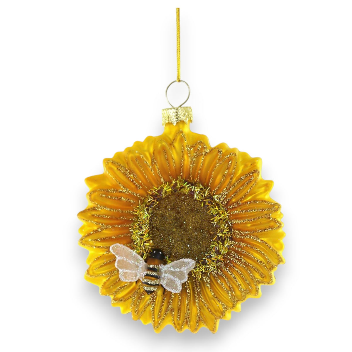 The CODY FOSTER SUNFLOWER WITH BEE ORNAMENT features gold glitter accents and a charming bee, making it an ideal collector’s piece or gift for design lovers, displayed hanging by a gold string against a white background.