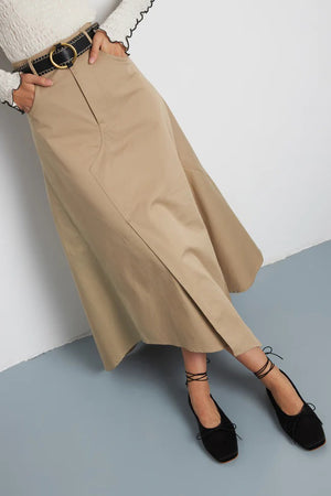 The Augusta - Sienna Ballet Flat by AUGUSTA is a single silver-colored shoe featuring a subtle metallic sheen and a simple bow on the front. It has a low brown sole and a pull tab at the back. Handcrafted in Spain from leather, this ballet flat is shown from the side against a light gray background.