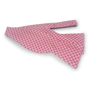 A vibrant red PETER-BLAIR Hot Air Balloons Silk Bow Tie by BIRD DOG BAY, featuring a charming repeating pattern of small, light pink ovals outlined in blue, is handmade in North Carolina and displayed against a crisp white background.