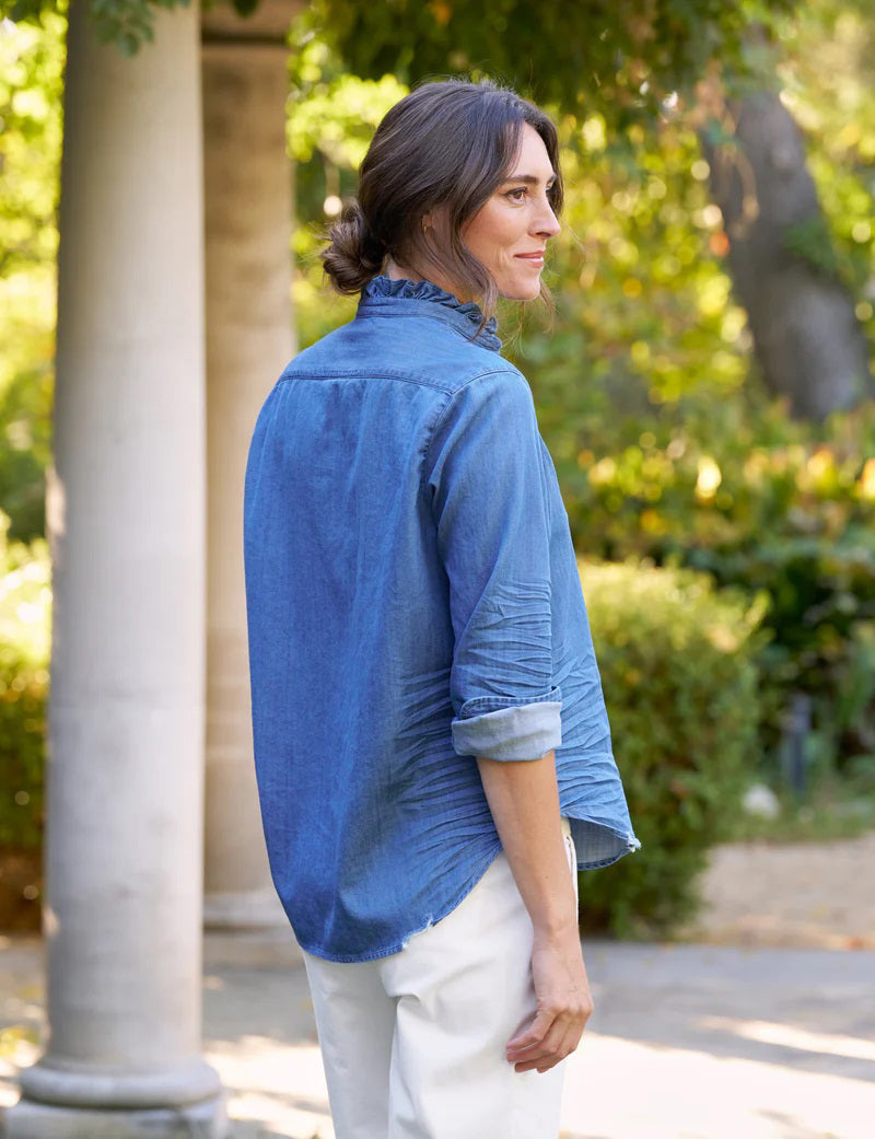 The FRANK &amp; EILEEN Ruffle Eileen Relaxed Button Up in Vintage Stonewashed Denim has rolled-up long sleeves, a casual frayed collar, front pocket, button-down front, and slightly curved hem. The label reads &quot;Frank &amp; Eileen EST 1947.