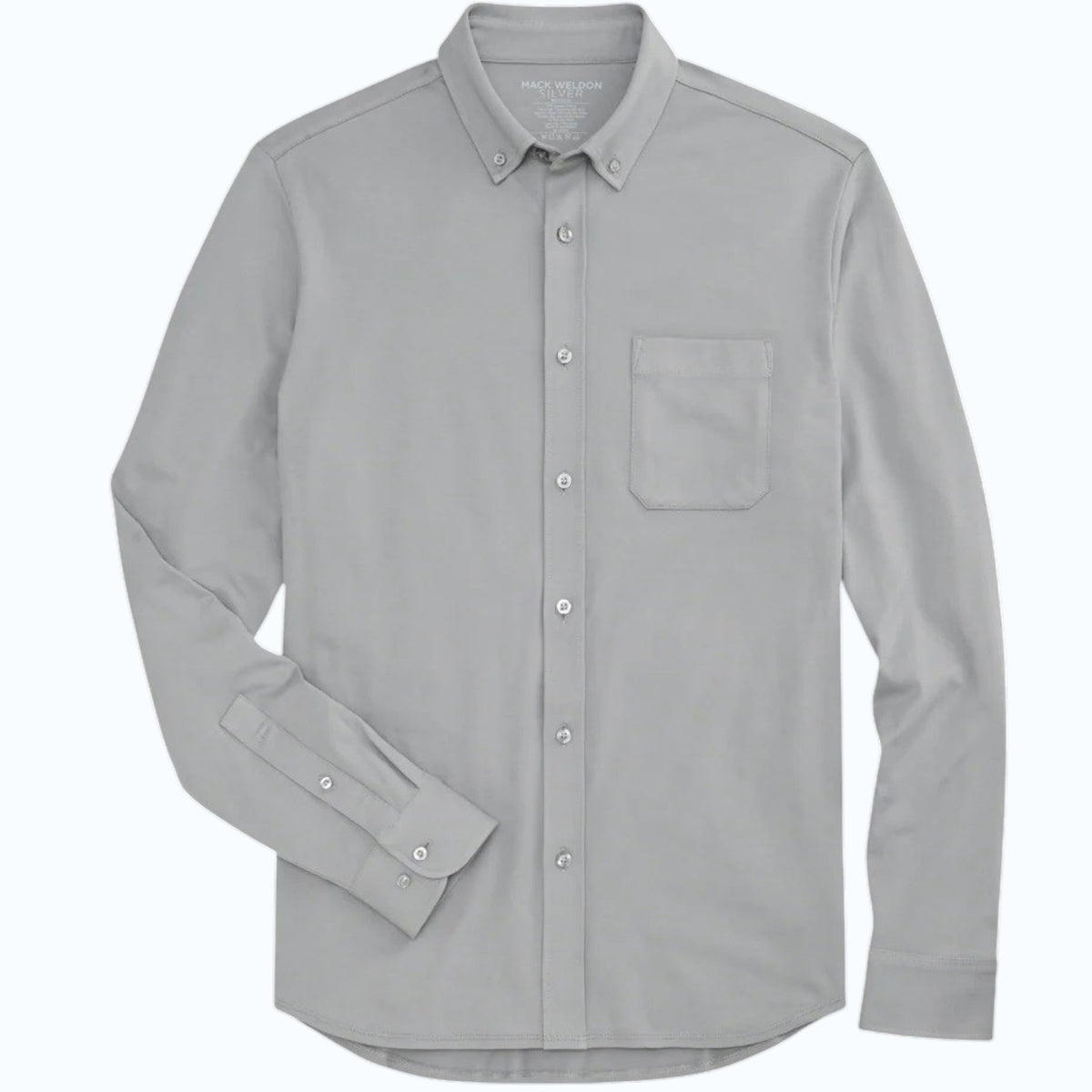A man faces forward against a plain background, buttoning up a Monument-colored MACK WELDON Silver Pique Long Sleeve Button Up Shirt. He looks slightly upward with a neutral expression and pairs the shirt with dark pants.