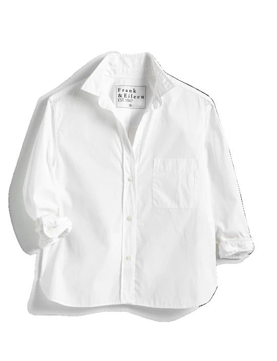 The FRANK &amp; EILEEN Silvio Untuckable Button-Up Shirt in Superluxe Cotton, featuring a chest pocket and rolled-up sleeves, is laid flat on a textured surface. The inside label reads "Frank &amp; Eileen EST 1947.