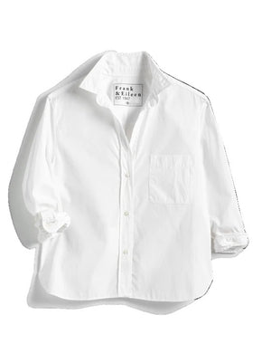The FRANK & EILEEN Silvio Untuckable Button-Up Shirt in Superluxe Cotton, featuring a chest pocket and rolled-up sleeves, is laid flat on a textured surface. The inside label reads "Frank & Eileen EST 1947.