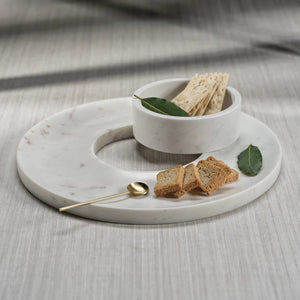 The ZODAX MARBELLA MARBLE CHIP & DIP SERVER is a round, white marble platter with subtle gray veining and a center bowl for dip. It measures 35.56 cm x 5.08 cm (14 in x 2 in) and is perfect for serving chips and dip.