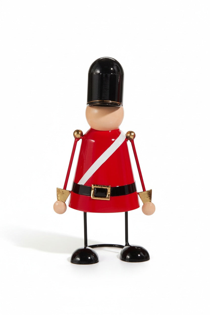 A 11-inch tall RED, WHITE AND BLACK NUTCRACKER - MEDIUM stylized figure wearing a red uniform, white sash, and tall black hat.