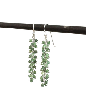 ANN LIGHTFOOT's Heishi Cut Green Aventurine Long Charm Earrings feature clusters of small green beads on sterling silver hooks, elegantly displayed on a dark rod.