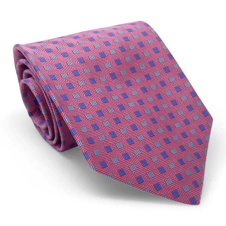 The BIRD DOG BAY PETER-BLAIR - BESPOKE SMALL SQUARES SILK TIE IN PINK is a handmade New York tie featuring a pink woven silk with repeating blue and purple squares on a white background.