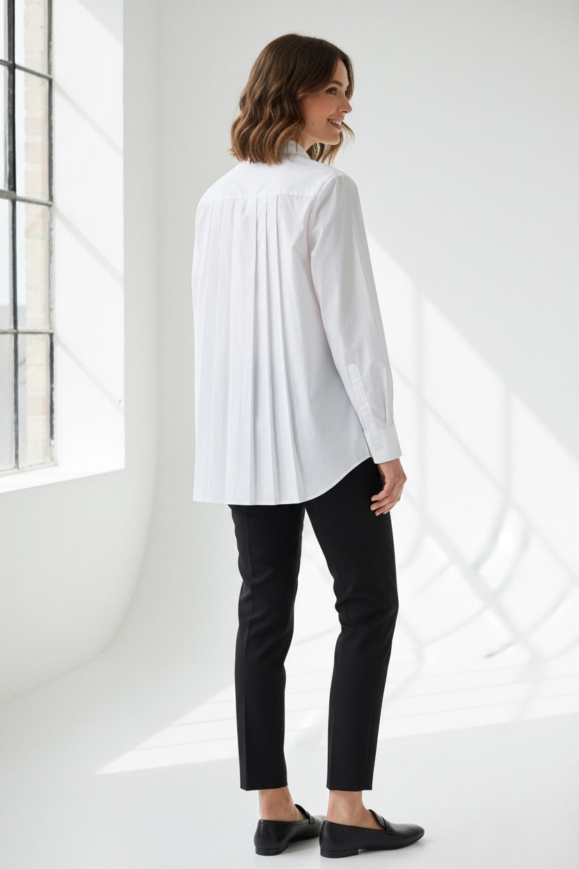 A person with straight brown hair is shown from the back, wearing the HINSON WU SARA Long Sleeve Pleated Back Shirt and black pants, standing against a plain light background.