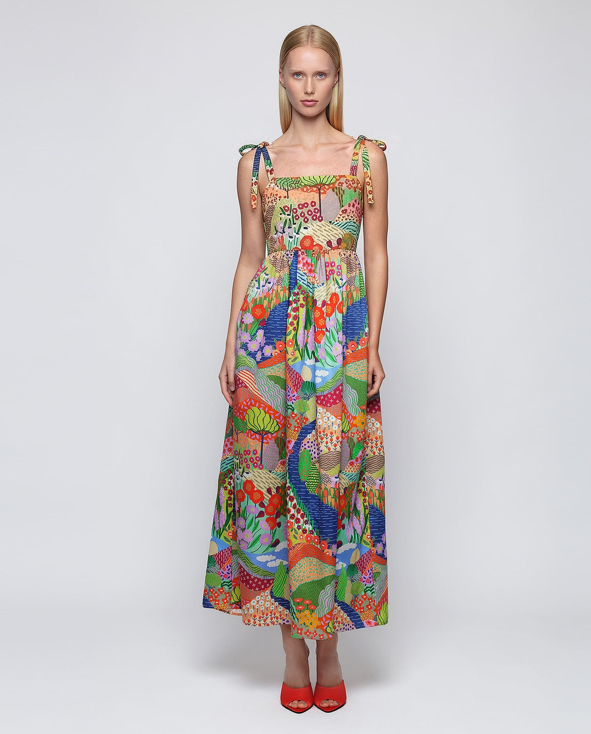 The MIRTO 1956 Multicolor Print Maxi Dress is a sleeveless cotton dress with tie straps, a square neckline, and a vibrant patchwork of floral and geometric designs in red, green, blue, yellow, and purple.