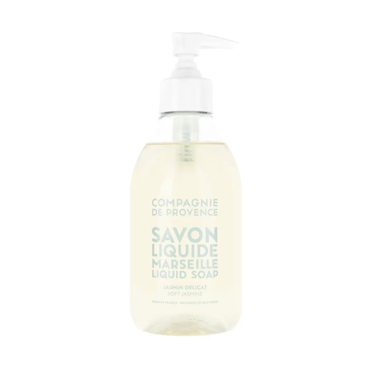 A clear pump bottle of COMPAGNIE DE PROVENCE - SAVON LIQUIDE DE MARSEILLE SOFT JASMINE 10OZ by CIE LUXE BRANDS, with light beige liquid and light blue label text, enriched with nourishing botanical oils.