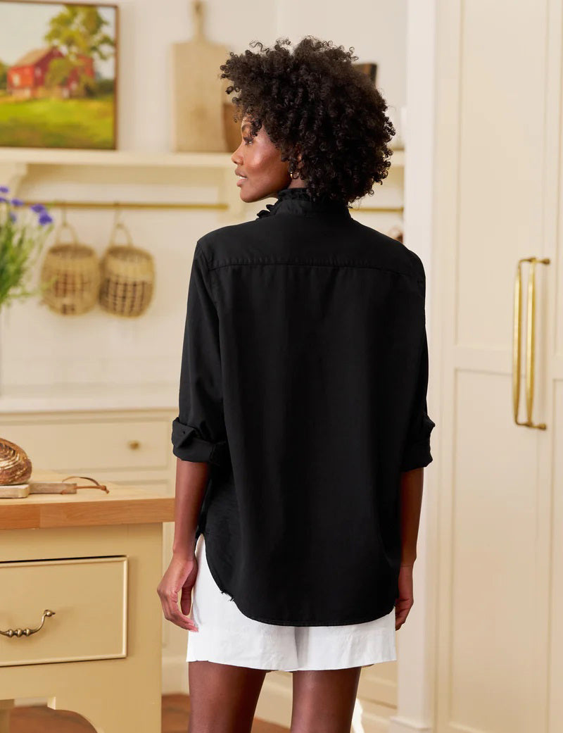 The FRANK &amp; EILEEN Ruffle Eileen Ruffle Collar Button Up Shirt in Famous Denim Blackout features long sleeves, white buttons, a single chest pocket, and a ruffled collar, shown laid flat against a white background.