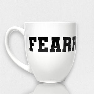 The FEARRINGTON LIFESTYLE COLLECTION - FEARRINGTON MUG by STRAN features the word "FEARLESS" boldly displayed in black, capital letters across its front. Perfect for your morning coffee, this ceramic mug rests on a white surface with a subtle shadow. The clean and minimalistic backdrop highlights its sleek design.