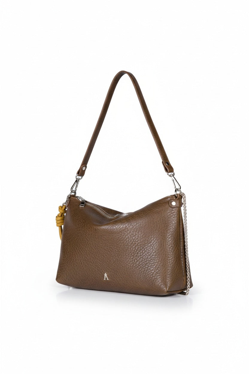 The CRAIE STUDIO - DUAL BUBBLE UMBER HANDBAG features brown bubble-textured leather, a gold zipper, and a chain strap. A large yellow knotted cord adorns one side for a unique decorative touch. The open bag reveals its interior and showcases the signature artistry of CRAIE STUDIO.