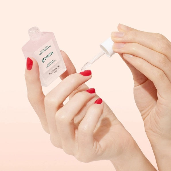 A bottle of MANUCURIST - GREEN™ DRYING DROPS by MANUCURIST INC features a white cap and contains a pale pink liquid. The label displays “Express Dry Intense Nutrition,” making it an ideal addition to your quick-dry manicure routine, as it nourishes cuticles for healthier, more beautiful nails.