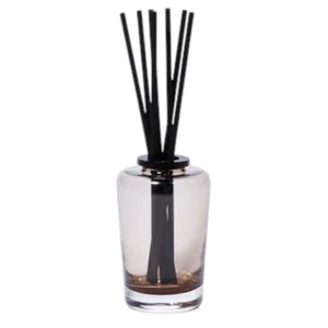 A black rectangular ZODAX gift box with a small label sits beside the THISTLE ESTATE DIFFUSER - 200 ML, featuring black reeds and scented liquid for a refreshing California coast fragrance.