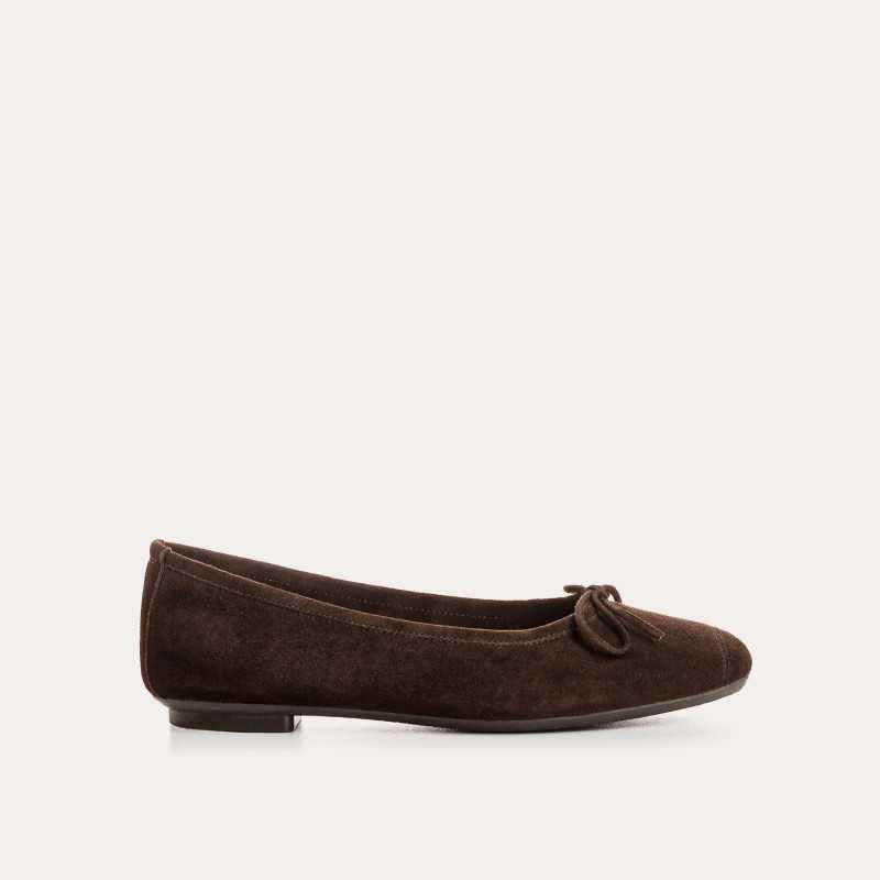 The REQINS HARMONY suede ballerina flats in Marron feature a dark brown finish and a small bow on the toe, shown in side profile against a plain light background—a timeless choice for any classic wardrobe.