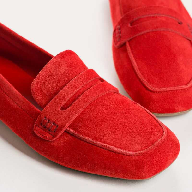The REQINS HEMA Suede Loafer in Rouge features bright red suede, low heels, a classic penny loafer design, and a supple leather insole—all crafted with artisanal expertise and shown on a plain light background.