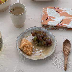 Two views of the CREATIVE COOP ORGANIC-SHAPED STONEWARE PLATE WITH REACTIVE GLAZE: one from above and one from the side, showcasing its scalloped edge and textured surface—a refined artisanal dinnerware piece.