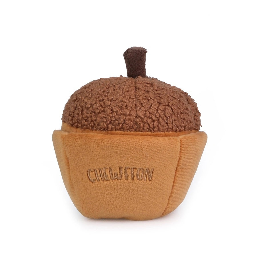 A plush, squeaky dog toy from CHEWFFON shaped like an acorn, featuring a textured brown top and a smooth tan base. The word “CHEWFFON” is embroidered on the base in light brown thread. This toy is called the ACORN SNUFFLE &amp; SQUEAKY DOG TOY.