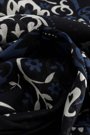 The MAISON LECOMTE - COSTA BRAVA BLACK SARONG by MAISON LECOMTE FLAMENT, featuring a white and blue paisley pattern, is tied in a loose knot against a plain white background.