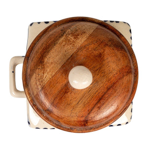 A close-up of the CREATIVE COOP HAND-PAINTED STONEWARE CANISTER WITH LID AND SPOON shows blue floral designs on cream stoneware and an acacia wood lid—an elegant farmhouse kitchen accent.