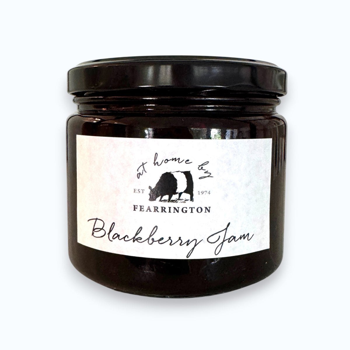 The FEARRINGTON SIGNATURE COLLECTION - FEARRINGTON HOUSEMADE BLACKBERRY JAM features a stylish black and white striped ribbon tied around the lid. The label reveals ingredients including blackberry, vanilla, lemon, pectin, and sugar. This handcrafted jam is made with meticulous care and is an ideal hostess gift. Please be aware that it may contain allergens.