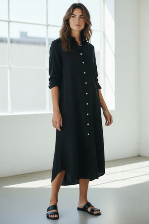 The FRANK & EILEEN Rory Maxi Shirtdress in Famous Denim Black features a collared, button-up design with a chest pocket, rolled long sleeves, and a curved hem, crafted from soft Italian cotton and displayed against a light textured background.