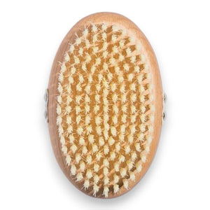 THE DRY BODY BRUSH by U BEAUTY features an oval wooden design with dense, light bristles, perfect for dry brushing and exfoliating to enhance your skin cleansing routine.