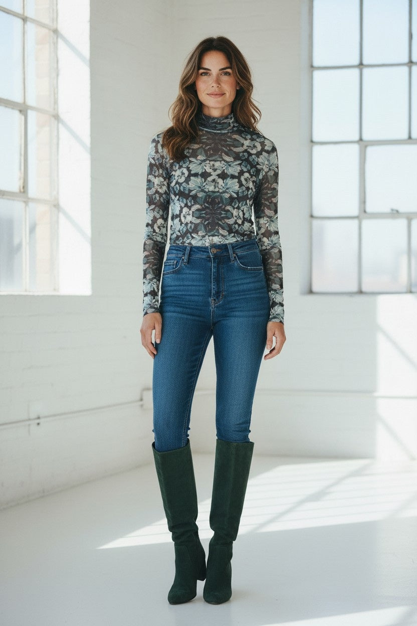 The FRANCO FERRARI - BALLET MESH TOP is a long-sleeved mesh turtleneck with a symmetrical floral pattern in gray, white, blue, and pink, shown on a white background.