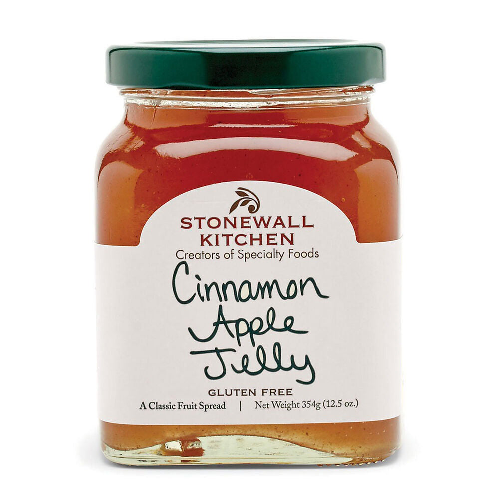 A jar of STONEWALL KITCHEN - CINNAMON APPLE JELLY with a green lid features a label that reads "Stonewall Kitchen, Creators of Specialty Foods" alongside "Cinnamon Apple Jelly, Gluten Free, A Classic Fruit Spread, Net Weight 345g (12.5 oz.)". This amber-hued jelly is perfect for breakfast breads and is made with Granny Smith apples.