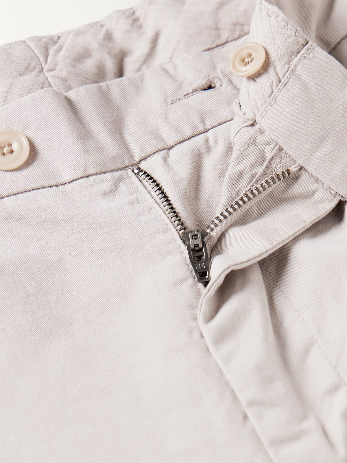 A close-up of the HARTFORD - TAYLOR PANTS IN STONE shows a buttoned back pocket, belt loop, and visible stitching on the waistband of these straight-leg men's pants.