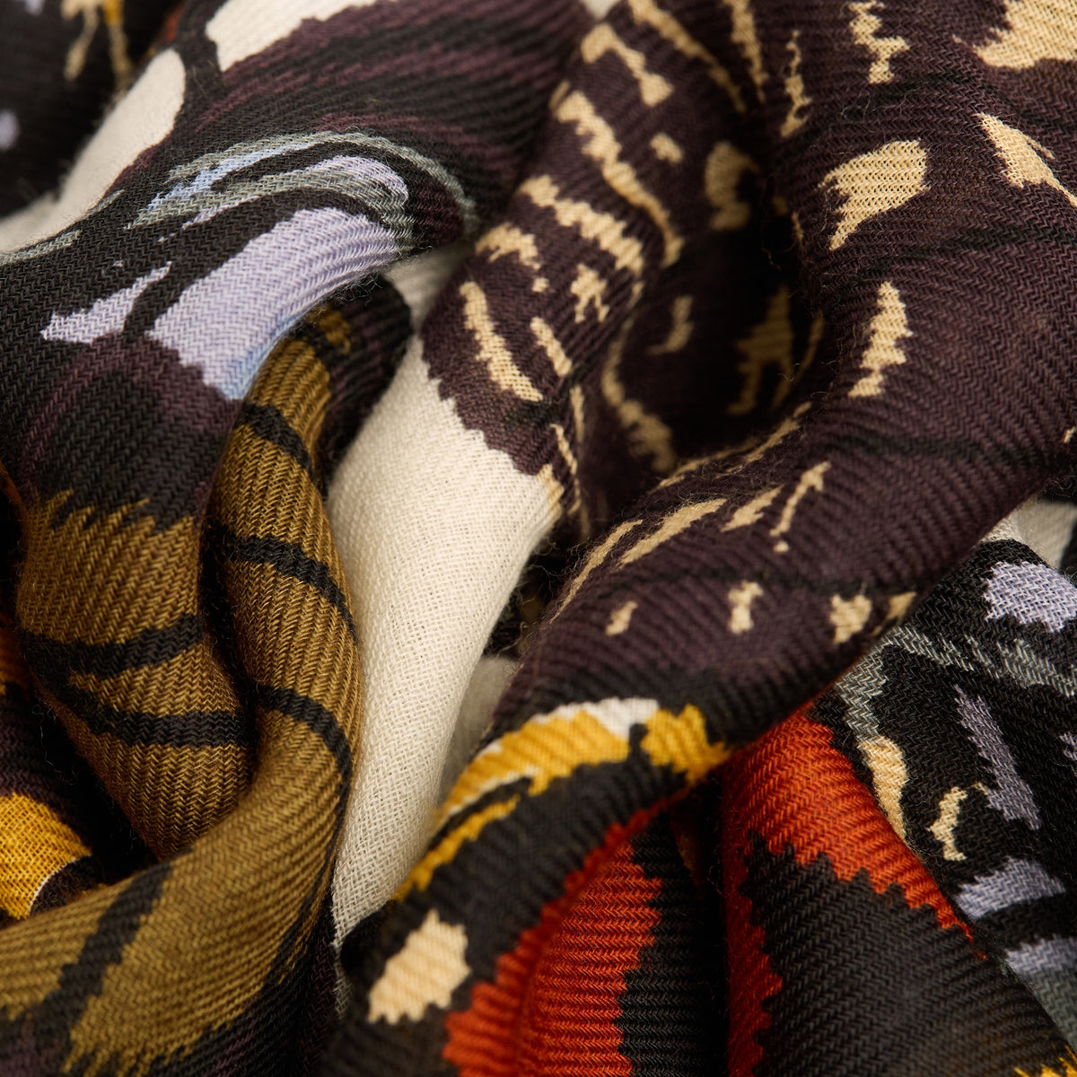 A person dressed in dark attire models the INOUI EDITIONS PAPILLONS (BUTTERFLIES) wool scarf in white by INOUI, featuring a colorful butterfly wing pattern, against a plain white background.