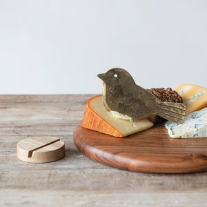 The HAND-FORGED METAL BIRD-SHAPED CHEESE KNIFE WITH MANGO WOOD STAND from CREATIVE COOP features a charming, simple bird design on a round wooden base, shown against a plain white background.