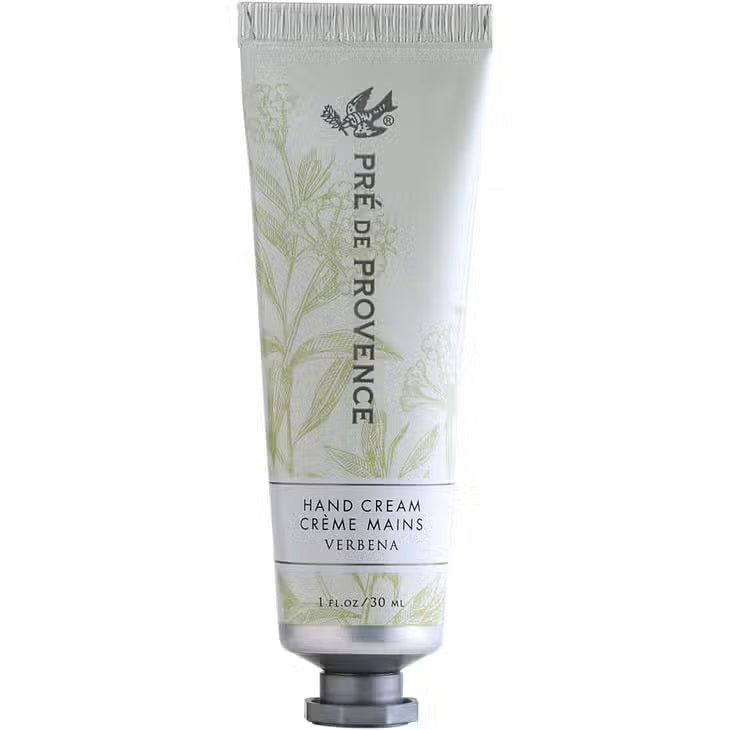 A tube of HAND CREAM VERBENA by EUROPEAN SOAPS, LLC, enriched with organic shea butter, is shown. The primarily white tube with green accents features delicate botanical illustrations. It contains 1 ounce (30 ml) of luxurious moisturizer and has a screw-on cap at the bottom.