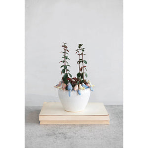 The PLANTER W BIRDS ON RIM by CREATIVE COOP is a ceramic piece made entirely from stoneware, showcasing a smooth, white exterior with small pastel-colored bird sculptures—yellow, pink, and blue—gracefully adorning the rim.