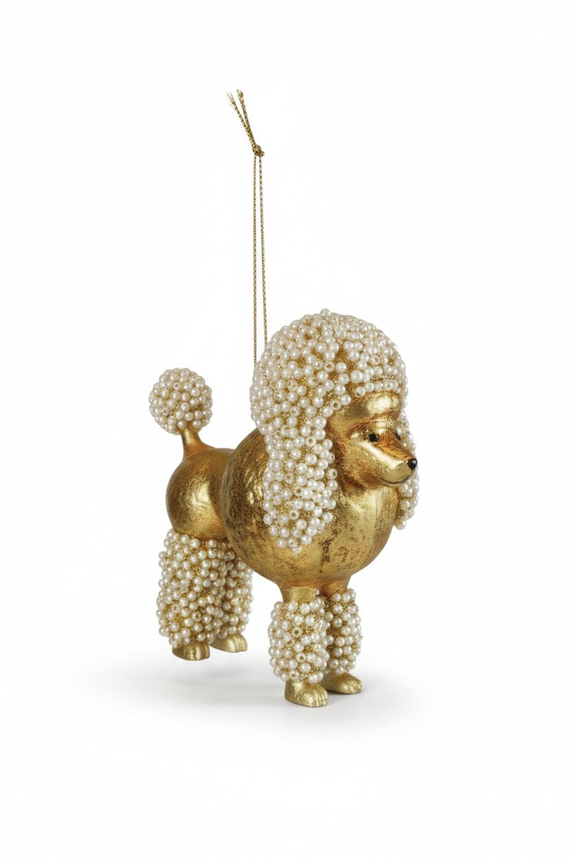 POODLE ORNAMENT WITH FAUX PEARLS, a gold glass poodle decorated with faux pearls on its head, tail, and legs, suspended by a gold string.