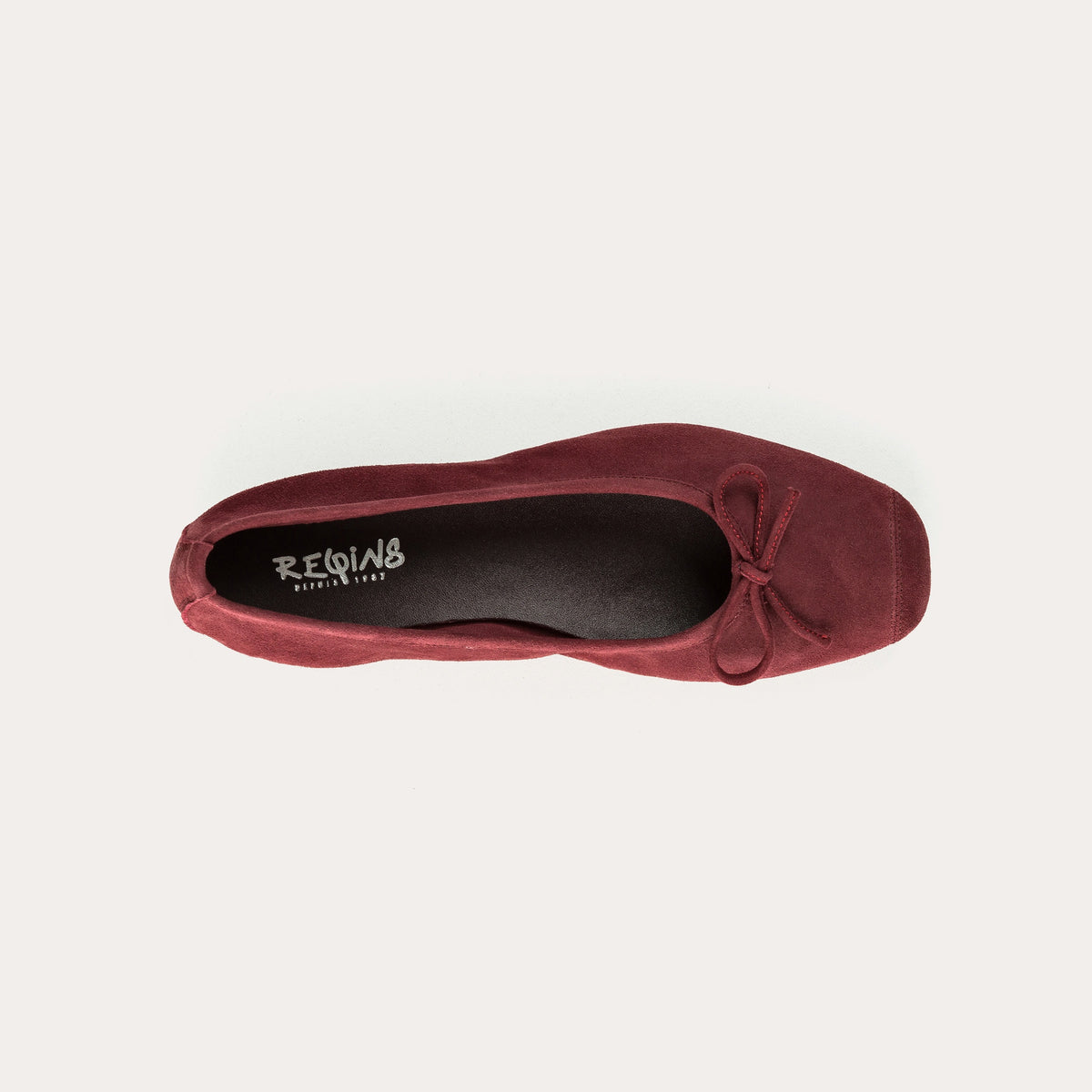 The REQINS - HARMONY Suede Ballerina Flats in Bordeaux, featuring elegant small bows on the toes, are displayed on a plain light background.