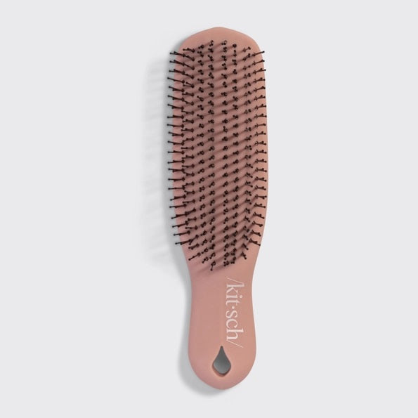 A KITSCH - Scalp Renewal Brush in Terracotta is displayed beside its box packaging, which features the product name and emphasizes its gentle, soothing scalp massage benefits as well as its eco-friendly materials. This nylon bristle brush by KITSCH is ideal for refreshing your scalp and effortlessly promoting healthy hair.