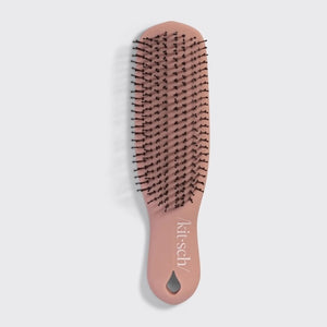 A KITSCH - Scalp Renewal Brush in Terracotta is displayed beside its box packaging, which features the product name and emphasizes its gentle, soothing scalp massage benefits as well as its eco-friendly materials. This nylon bristle brush by KITSCH is ideal for refreshing your scalp and effortlessly promoting healthy hair.