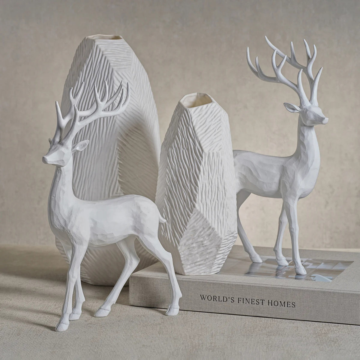 The ZODAX ALL WHITE DECORATIVE DEER features two resin deer sculptures with smooth, faceted textures, resembling carved wood. Each measures 8.5 x 13.75 inches and is perfect for display on any white background.