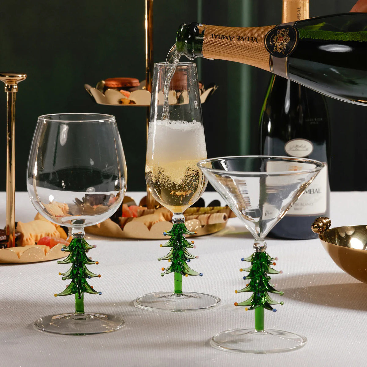 The ZODAX TREETOP CHEERS CHAMPAGNE FLUTE features a clear bowl and a festive green Christmas tree stem with colorful ornaments. Holds 7.78 oz (230 ml).