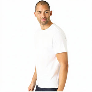 A man with short hair and light stubble wears the MACK WELDON Slub Cotton Crew Neck T-Shirt in Bright White, paired with dark pants, standing against a white background and looking slightly to his left.