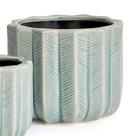 The NAPA HOME AND GARDEN - VELA POT, LARGE by NAPA HOME AND GARDEN features a fully visible ceramic planter with a light blue chevron pattern and textured vertical ridges, forming part of a charming decorative set. A smaller matching pot is partially displayed in the foreground on the left.