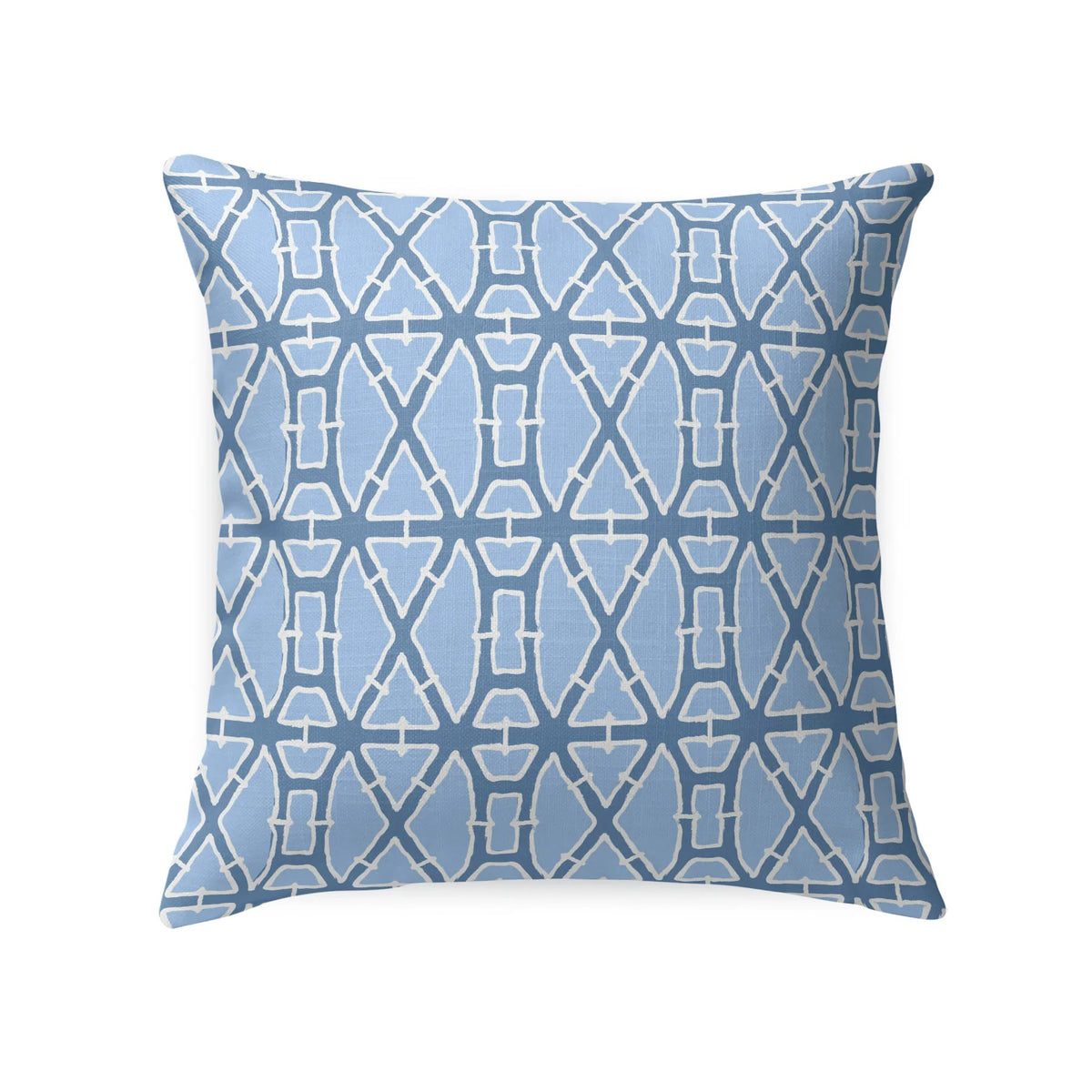 A woven rattan chair with a white cushion and the LOOM AND CLOTH - LATTICE TAILORED PILLOW IN BLUE by LOOM & CLOTH sits next to a white nightstand with vases against a blue floral wallpapered wall.