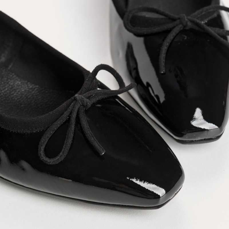 The REQINS FETICHE heeled ballerina shoe features black patent leather, a rounded toe, small bow detail, and a block heel, shown on a plain white background.