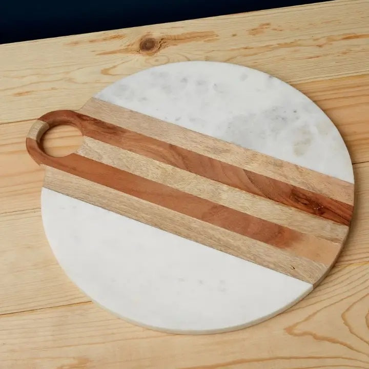 The BE HOME - MOA Marble & Wood Round Board by BE HOME, INC is handmade in India, featuring a central wooden stripe on white marble and finished with a circular top handle.
