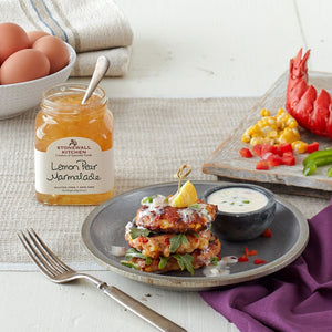 A jar of STONEWALL KITCHEN - LEMON PEAR MARMALADE from STONEWALL KITCHEN, featuring a green lid and a handwritten-style label against a white background, highlights the vibrant blend of lemon and sweet pear marmalade flavors.