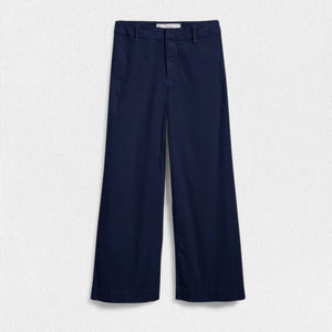 The FRANK & EILEEN Wexford Wide Leg Linen Pant in Navy is showcased against a light textured background. These high-rise trousers, crafted from Italian Performance Linen, feature a flat front and straight hem with a clean and minimalist design, absent of visible pockets or embellishments.